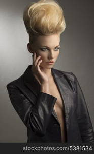 portrait of pretty girl with fashion rock look posing with modern creative hairdo and leather jacket