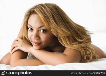 Portrait of pretty sexy woman lying on bed making eye contact.