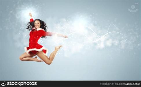 portrait of pretty snowgirl. Happy smiling woman in red xmas costume jumping high