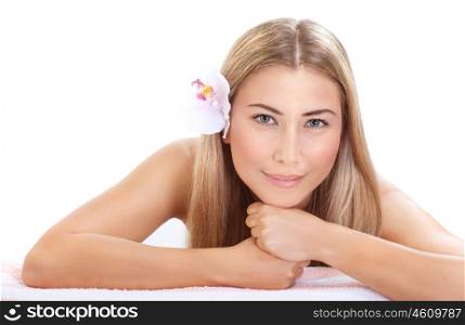 Portrait of pretty woman at spa, laying down on massage table, isolated on white background, fresh flower in head, enjoying dayspa