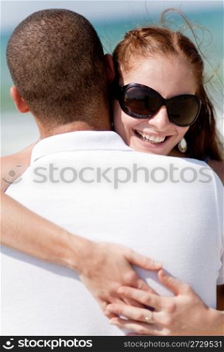 Portrait of pretty woman holding her husband while at beach,outdoor