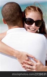 Portrait of pretty woman holding her husband while at beach,outdoor