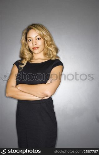 Portrait of pretty woman in black dress against gray background.