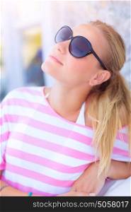 Portrait of pretty woman relaxing outdoors, with closed eyes enjoying warm sunny day, summer vacation, pleasure concept