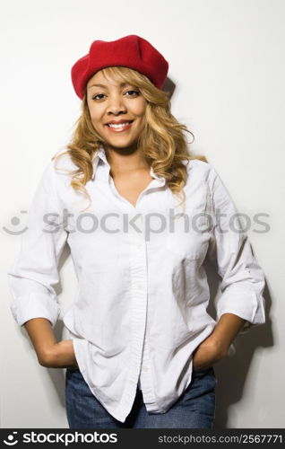 Portrait of pretty woman standing against white background smiling.