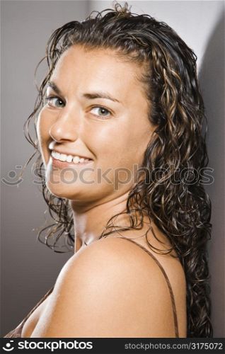 Portrait of pretty young adult Caucasian brunette female smiling and looking at viewer.
