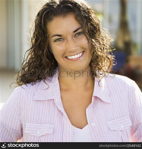 Portrait of pretty young adult Caucasian brunette woman smiling and looking at viewer.