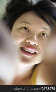 Portrait of pretty young Asian woman lying in bed smiling.