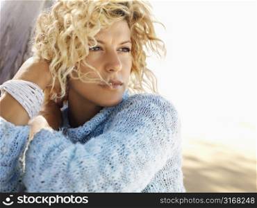 Portrait of pretty young blond woman sitting on Maui, Hawaii beach.