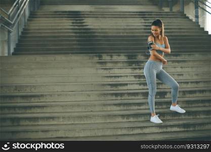 Portrait of pretty young female runner resting on stairs