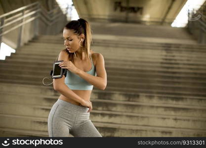 Portrait of pretty young female runner resting on stairs