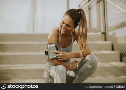 Portrait of pretty young female runner resting on the stairs