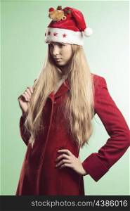 portrait of pretty young girl with long blonde hair, natural make-up and winter clothes. She wearing red coat and funny red santa claus hat