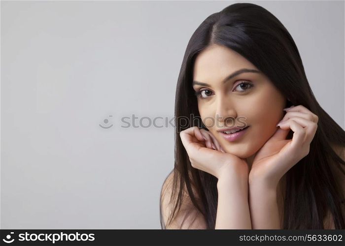Portrait of pretty young Indian woman with long hair isolated over colored background