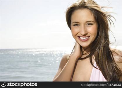 Portrait of pretty young smiling Caucasian woman with long brown hair at beach in Maui Hawaii.