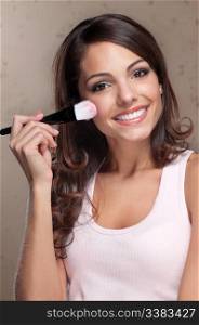 Portrait of pretty young woman applying cosmetic paint brush