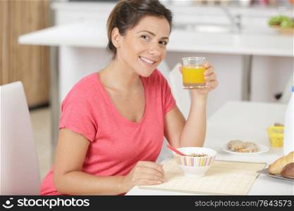portrait of pretty young woman having breakfast at home
