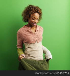 Portrait of pretty young woman standing against green background.