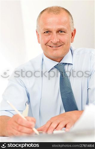 Portrait of professional architect businessman with pen sitting behind table
