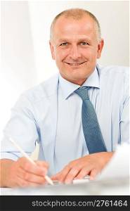 Portrait of professional architect businessman with pen sitting behind table