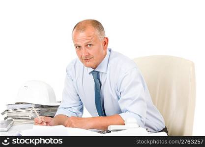 Portrait of professional architect with blueprints sitting behind table