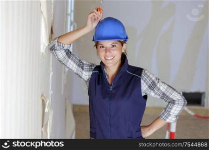portrait of professional female worker holding wallpaper scraper
