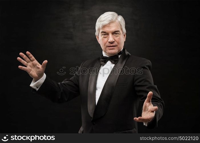 Portrait of professional hypnotist on black background