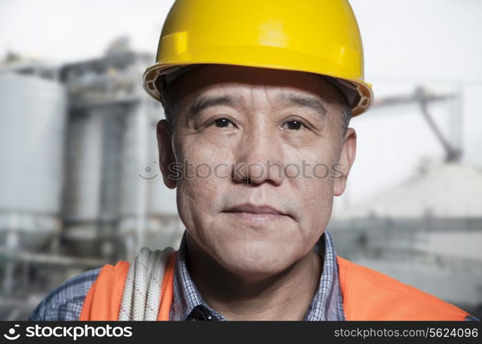 Portrait of proud worker in protective workwear outside of a factory