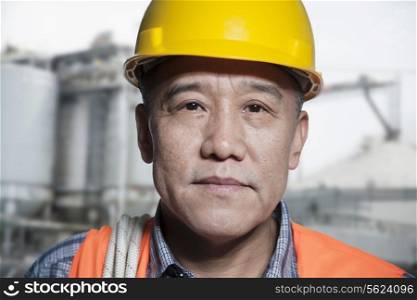 Portrait of proud worker in protective workwear outside of a factory