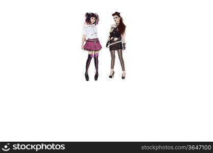 Portrait of punk females standing over white background