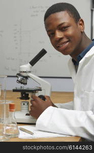 Portrait Of Pupil Using Microscope In Science Lesson