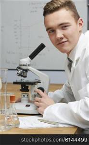 Portrait Of Pupil Using Microscope In Science Lesson