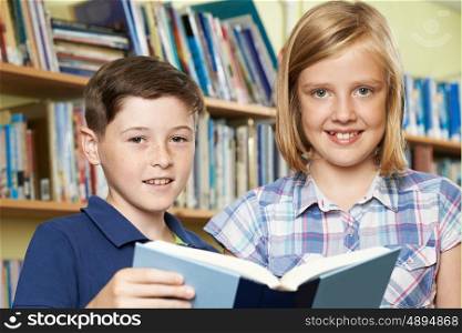 Portrait Of Pupils Reading Book In Library