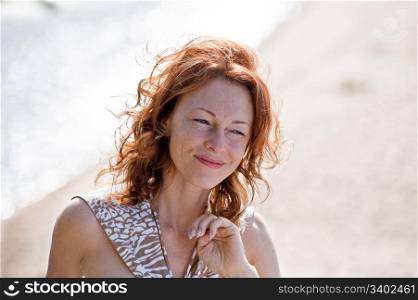 Portrait of red-haired adult women in dune at the sea