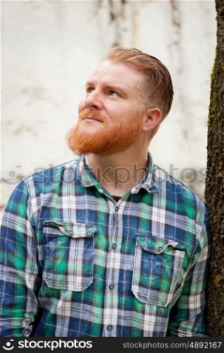 Portrait of red haired man with plaid shirt and long beard