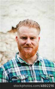 Portrait of red haired man with plaid shirt and long beard