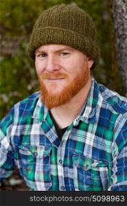 Portrait of red haired man with plaid shirt looking at camera