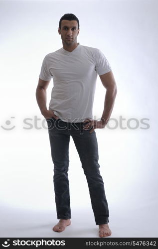 portrait of relaxed young man dressed in white shirt and jeans isolated over white background in studio