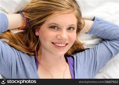 Portrait of relaxing lying young girl listening to music