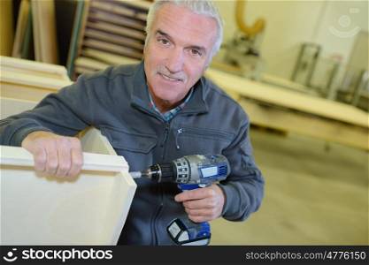 portrait of retired man working at his workshop