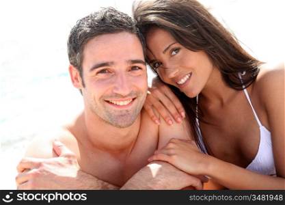 Portrait of romantic couple laying on the beach