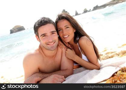 Portrait of romantic couple laying on the beach