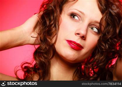 Portrait of romantic curly young woman girl in red dress on pink. Studio shot. Valentines Day.