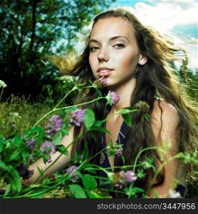 Portrait of romantic girl in flower meadow