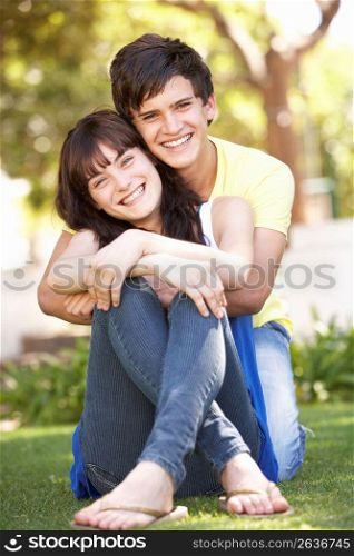 Portrait Of Romantic Teenage Couple Sitting In Park