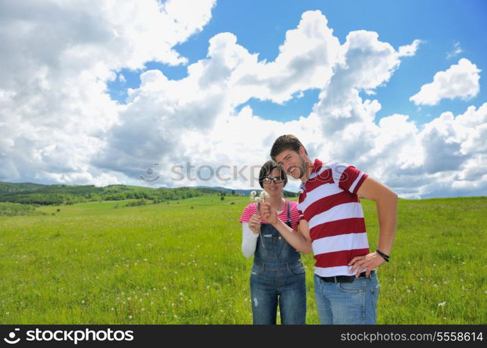 Portrait of romantic young couple in love smiling together outdoor in nature with blue sky in background