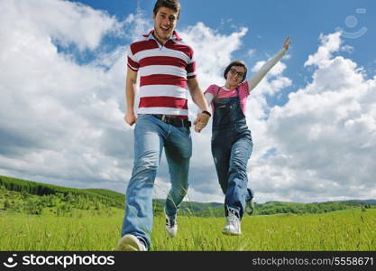 Portrait of romantic young couple in love smiling together outdoor in nature with blue sky in background