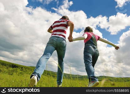 Portrait of romantic young couple in love smiling together outdoor in nature with blue sky in background