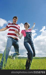 Portrait of romantic young couple in love smiling together outdoor in nature with blue sky in background