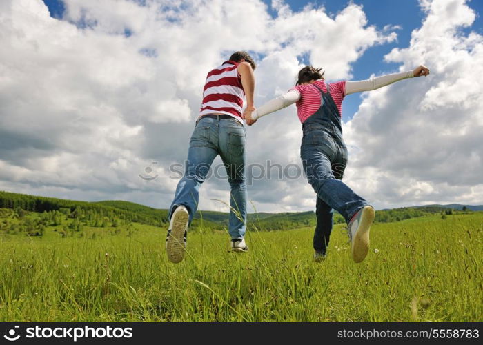 Portrait of romantic young couple in love smiling together outdoor in nature with blue sky in background